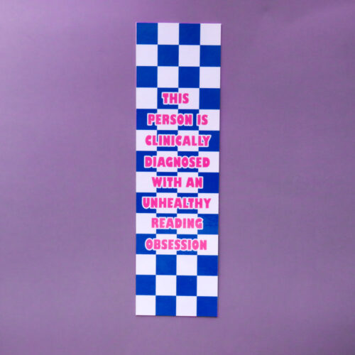 Blue and white checkered bookmark with pink text reading "This person is clinically diagnosed with an unhealthy reading obsession" on a purple background.