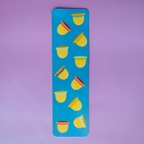 Vibrant blue bookmark with a playful, scattered arrangement of yellow and orange coffee cups with colorful rims.