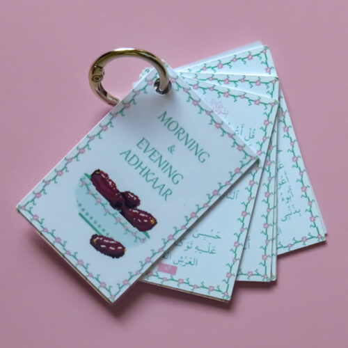 A small keychain on a metal ring featuring cards with an illustration of a bowl of dates and a green floral border, titled "Morning & Evening Adhkaar".
