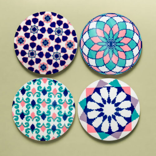 A set of four circular MDF coasters, each featuring a different intricate Islamic geometric rosette in vibrant shades of blue, teal, and pink.