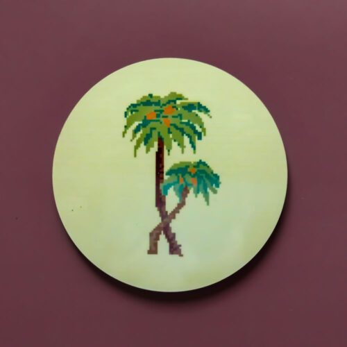 Circular MDF coaster with an illustration of two palm trees on a yellow background.